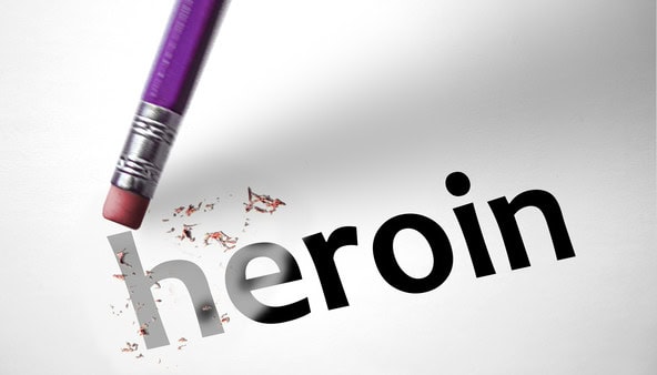 pencil eraser erasing the word heroin printed on a paper