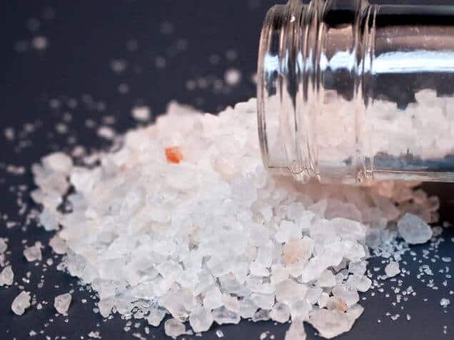 bath salts spilled from a bottle on a table 
