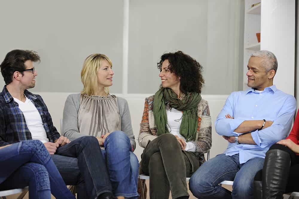 lighthouse-treatment-center-what-is-al-anon-article-image-of-happy-people-in-al-anon-meeting