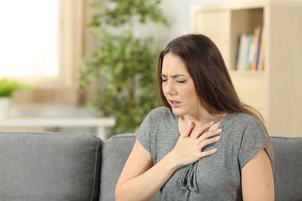 lighthousetreatment-what-is-fentanyl-and-why-is-it-so-dangerous-article-photo-woman-suffering-respiration-problems-sitting-on-a-couch-in-the-living-room-at-home-622524932