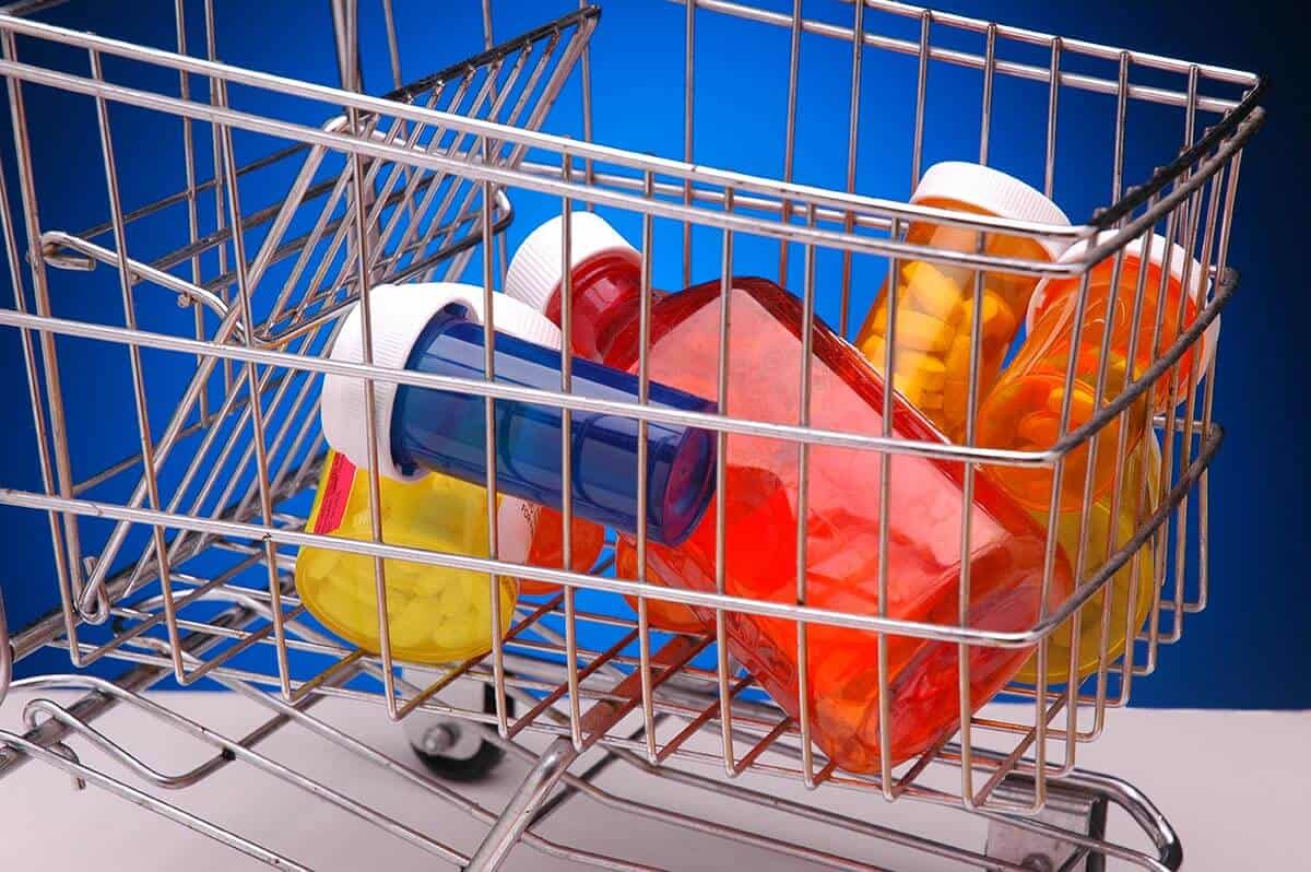 colorful pill bottles in a metal shopping cart