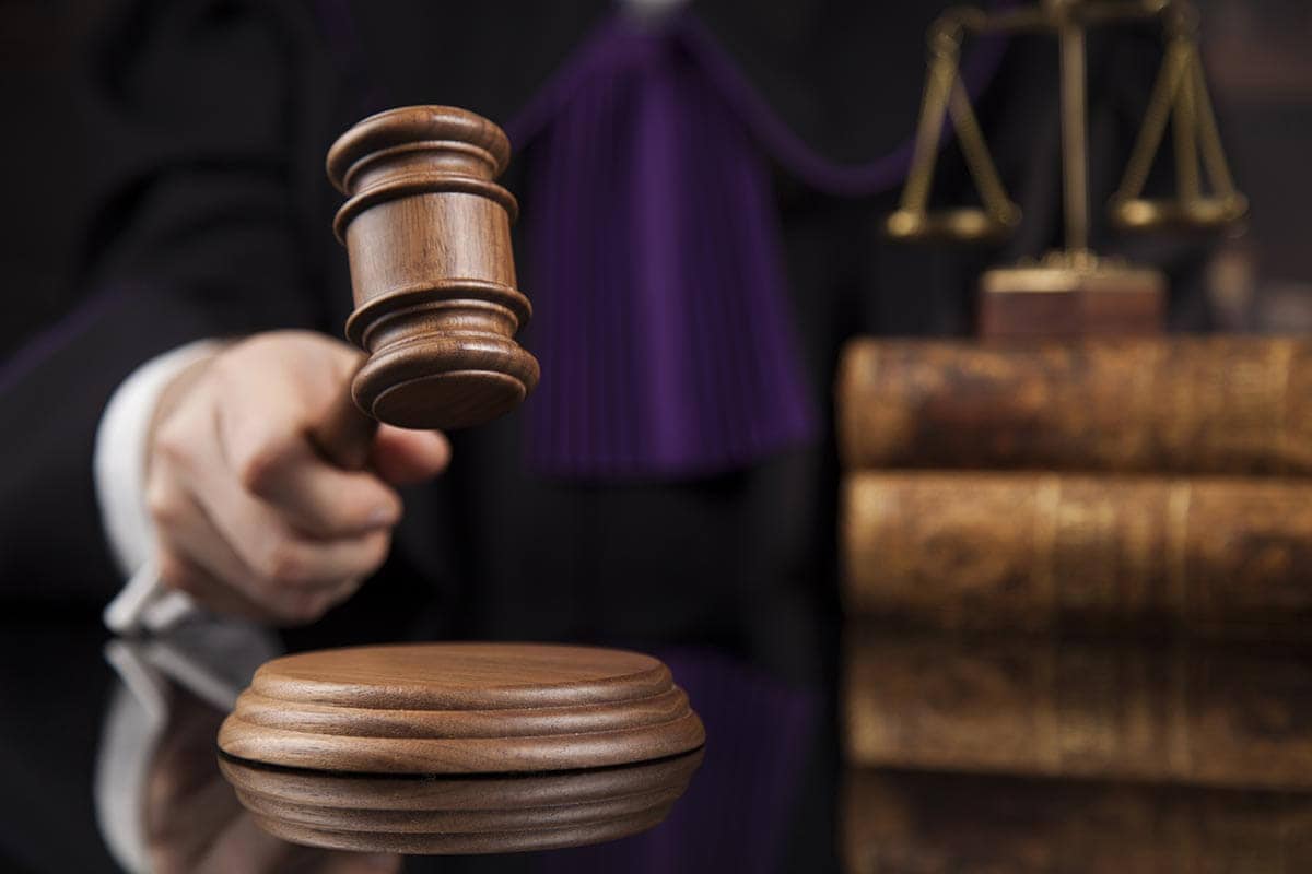 closeup of a judge's hand striking the gavel in a courtroom