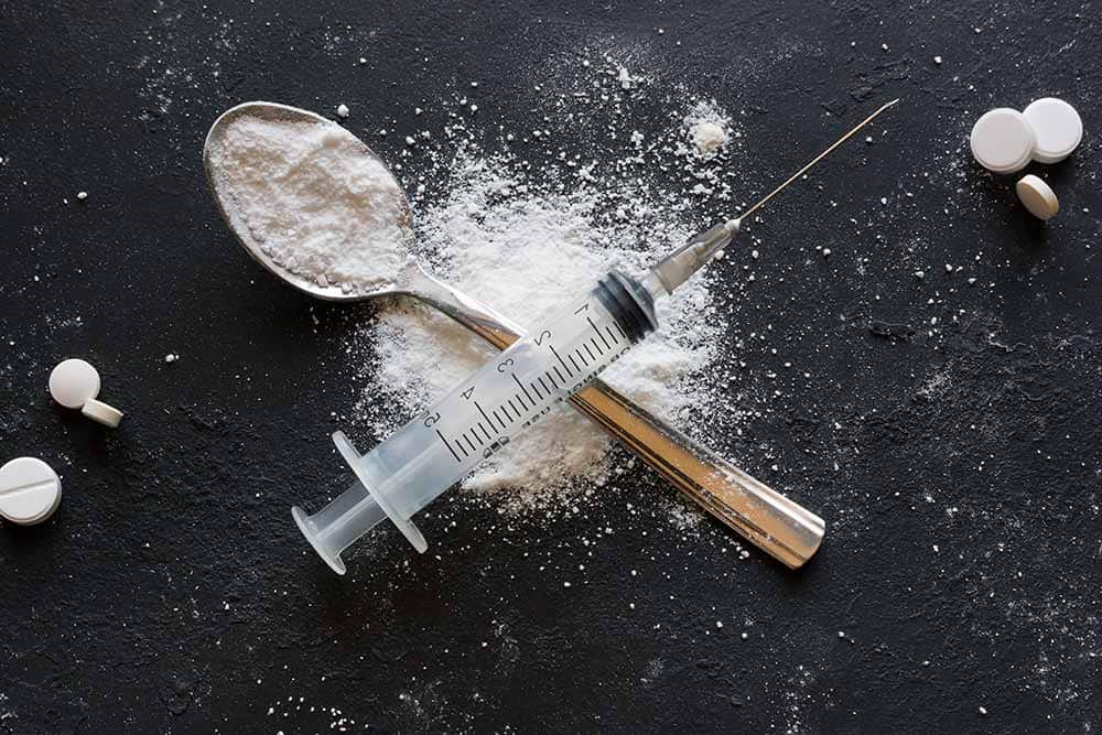 lighthousetreatment-what-is-heroin-cut-with-article-photo-spoon-and-syringe-in-the-form-of-a-cross-concept-stop-drug-addiction