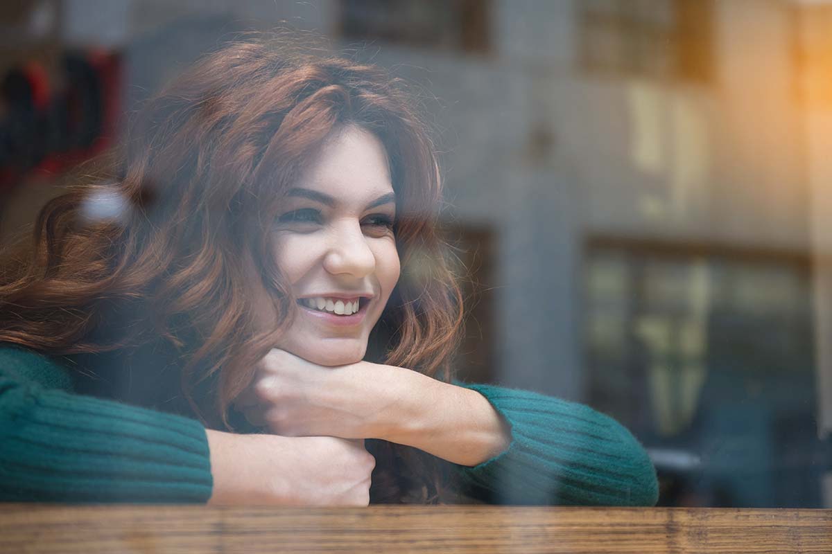 anaheimlighthouse-8-ways-to-teach-yourself-you-deserve-love-in-recovery-article-photo-of-happy-red-haired-young-woman-looking-over-the-window