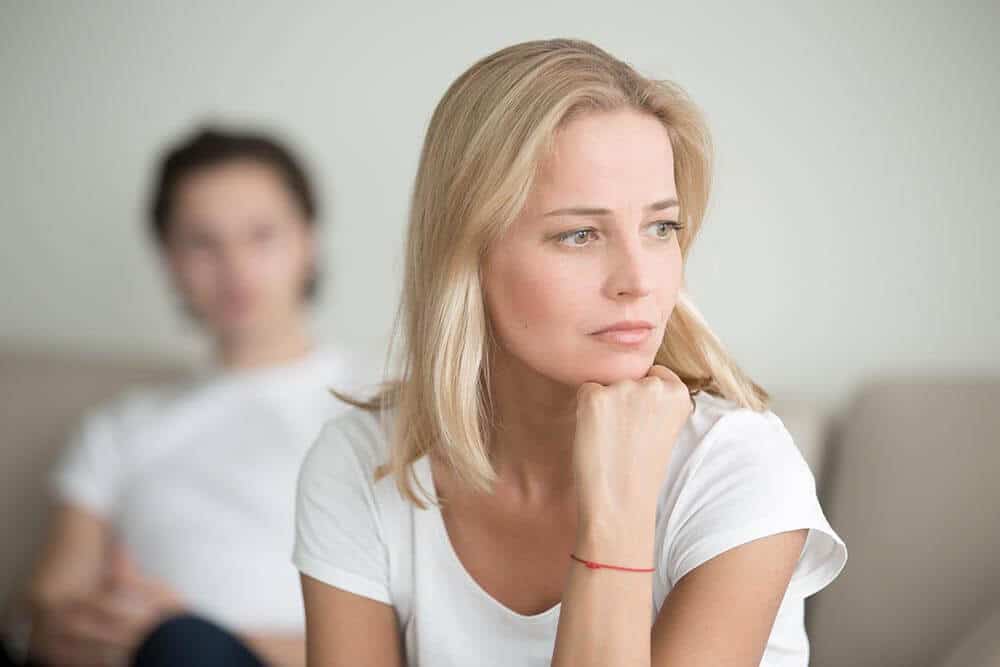 lighthousetreatment-how-to-detach-from-an-addict-with-love-article-photo-serious-sad-woman-thinking-over-a-problem-man-sitting-aside-end-of-long-term-relations-an-529004749