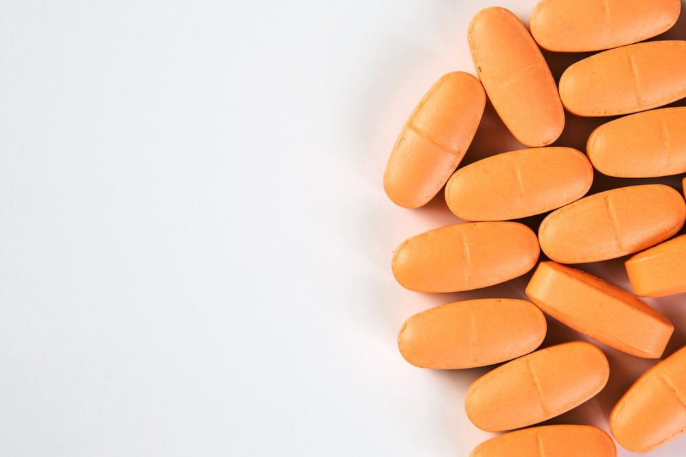 Several orange Xanax alprazolam pills on a white surface