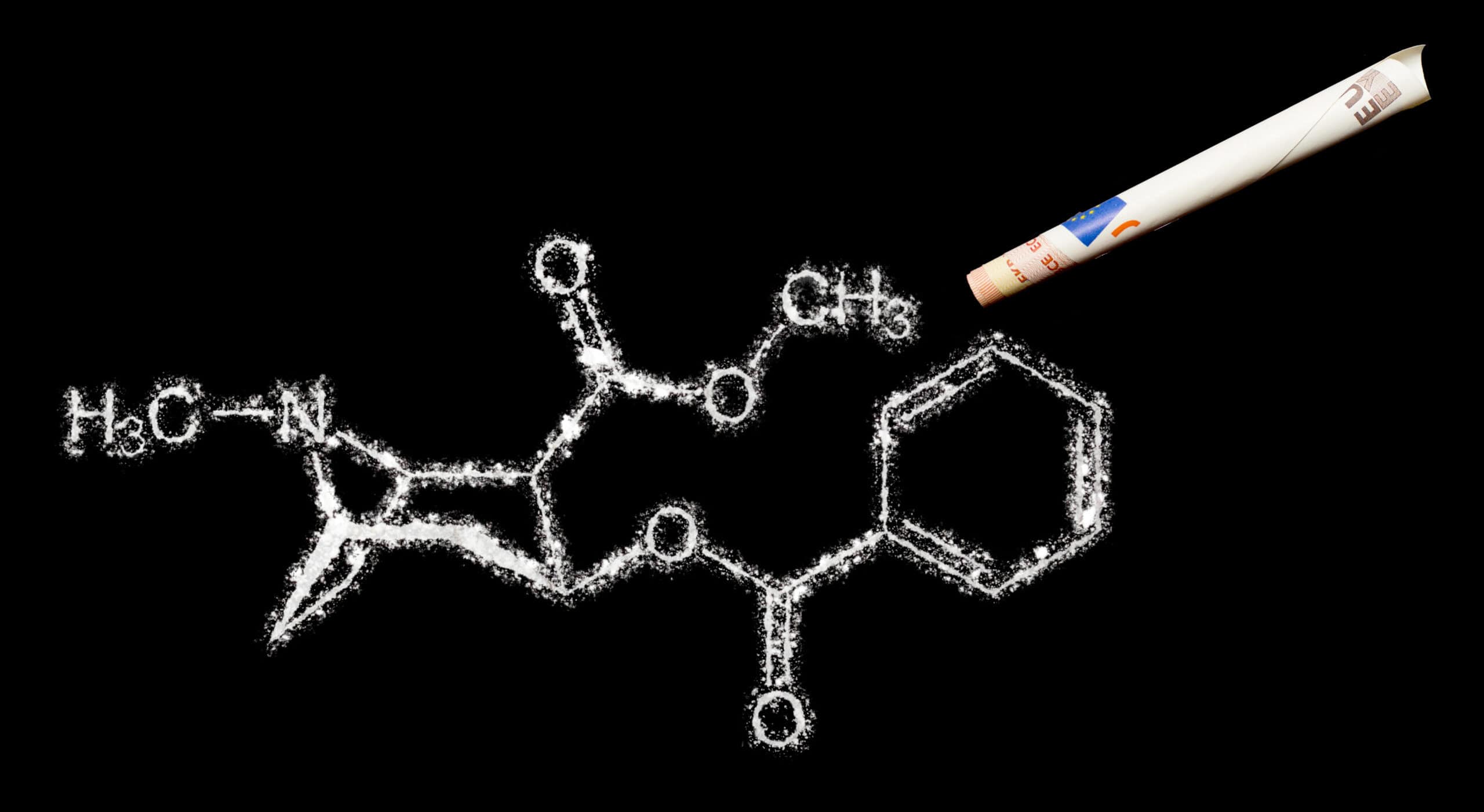 Chemical structure of cocaine drawn using a powder on black surface