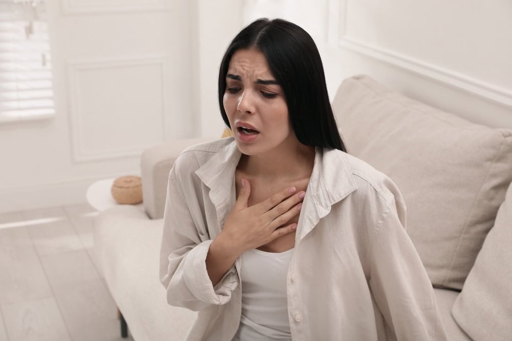 Woman suffering an anxiety attack inside the bedroom