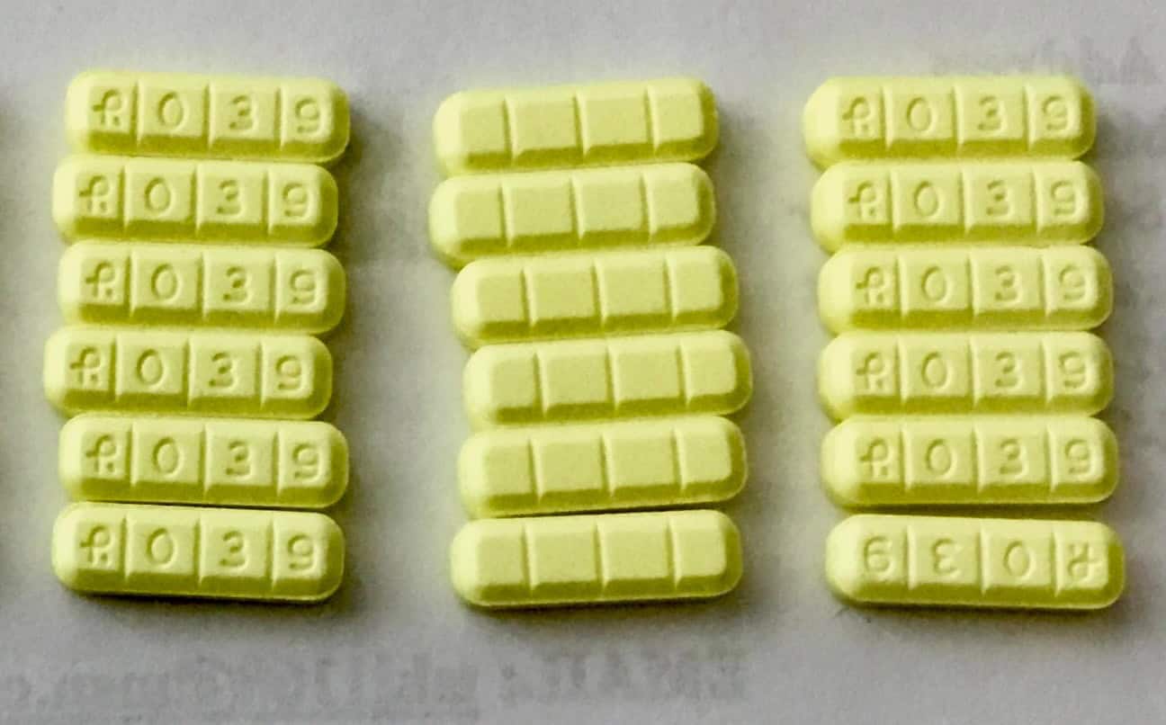 Even rows of R039 pills on a white surface
