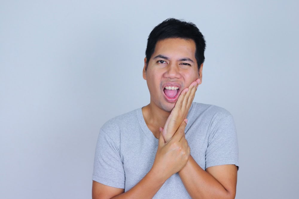 Man clutching on his jaw due to pain 