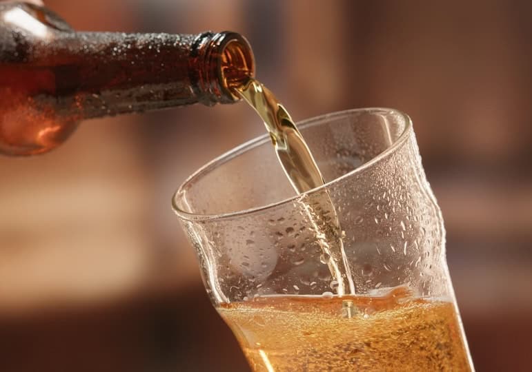 Beer being poured from a bottle into a mug 
