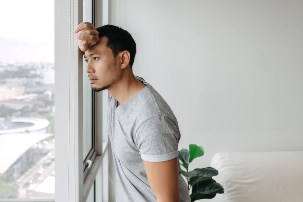Man looking out of a window pensive