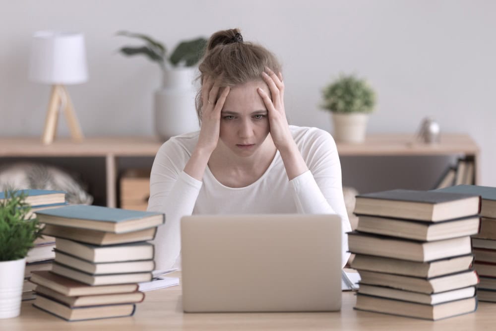 Male student slumped on a book trying to concentrate 