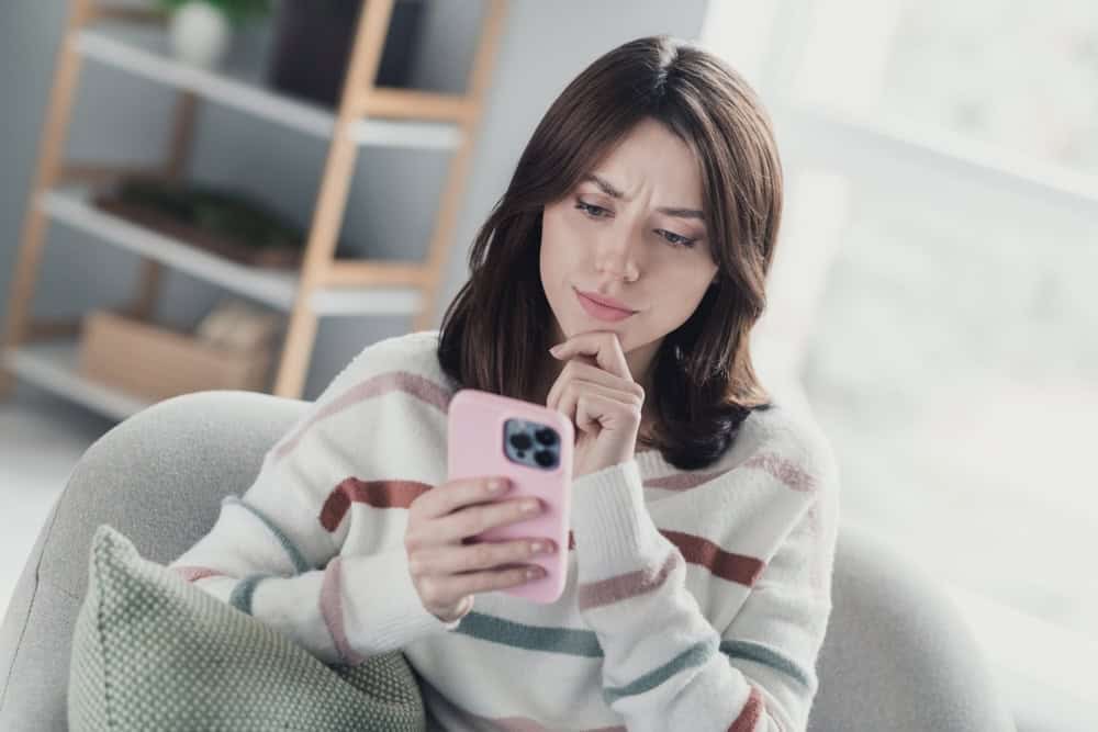 Woman using a cell phone with a questioning look on her face
