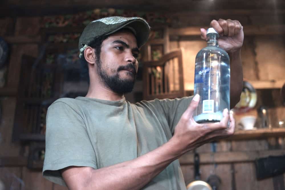 Man looking at an old bottle of vodka