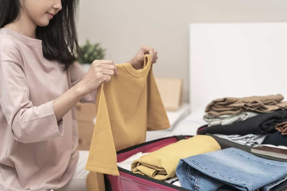 Woman packing clothes in her hand-carry luggage