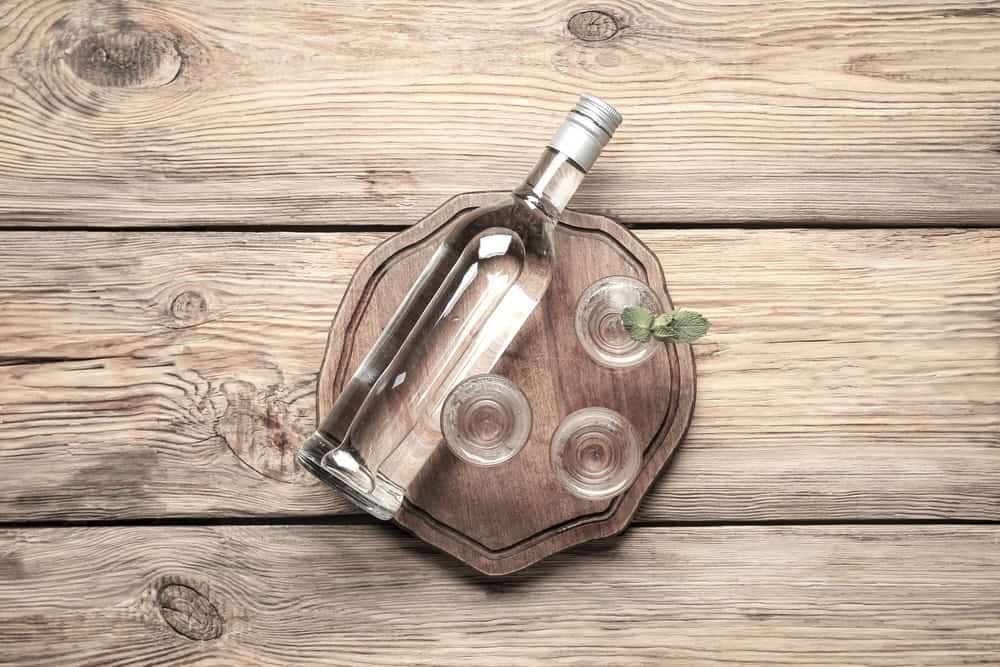 Bottle of tequila with shot glasses filled with tequila 