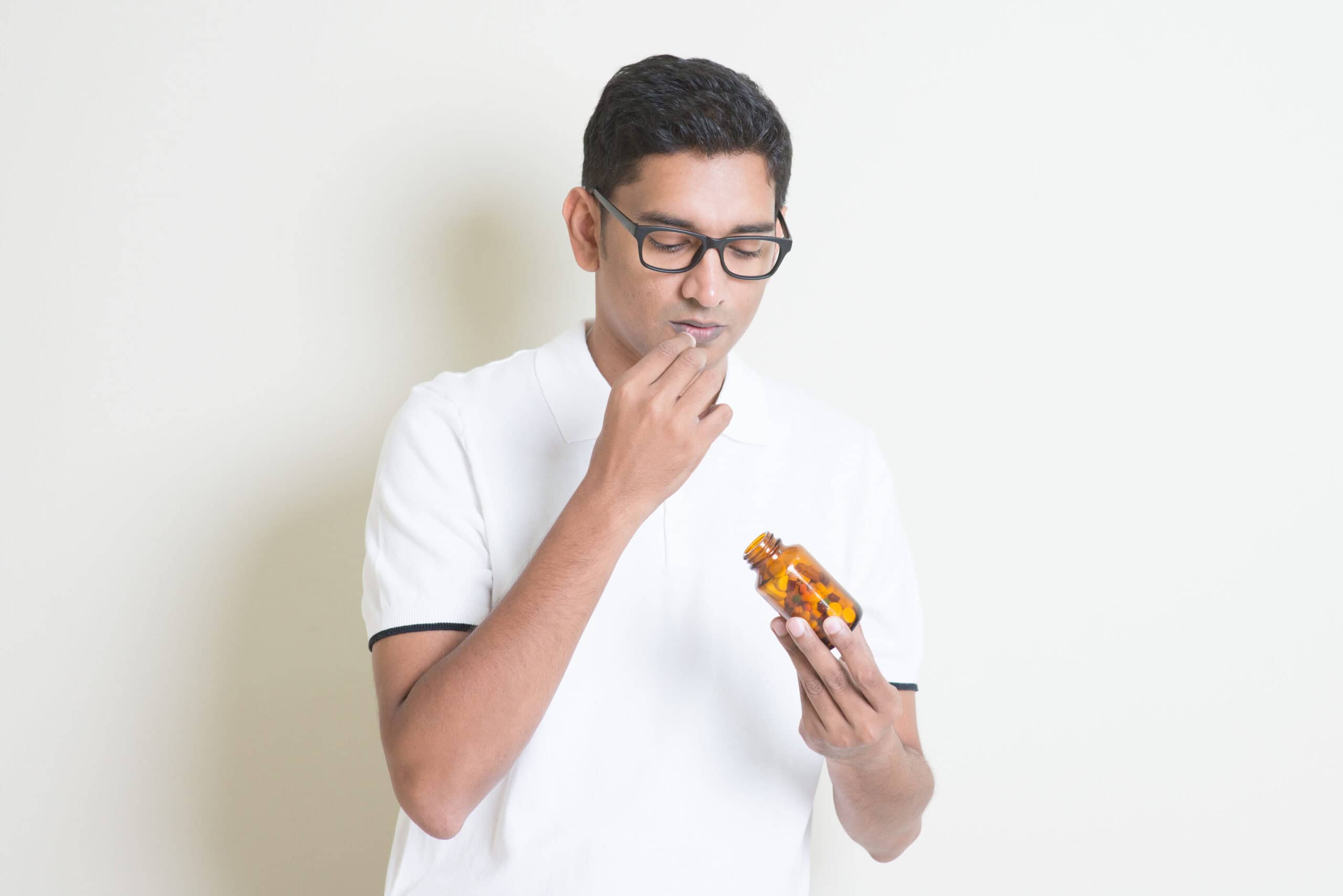 Man looking at a bottle of expired Adderall thinking if safe to use