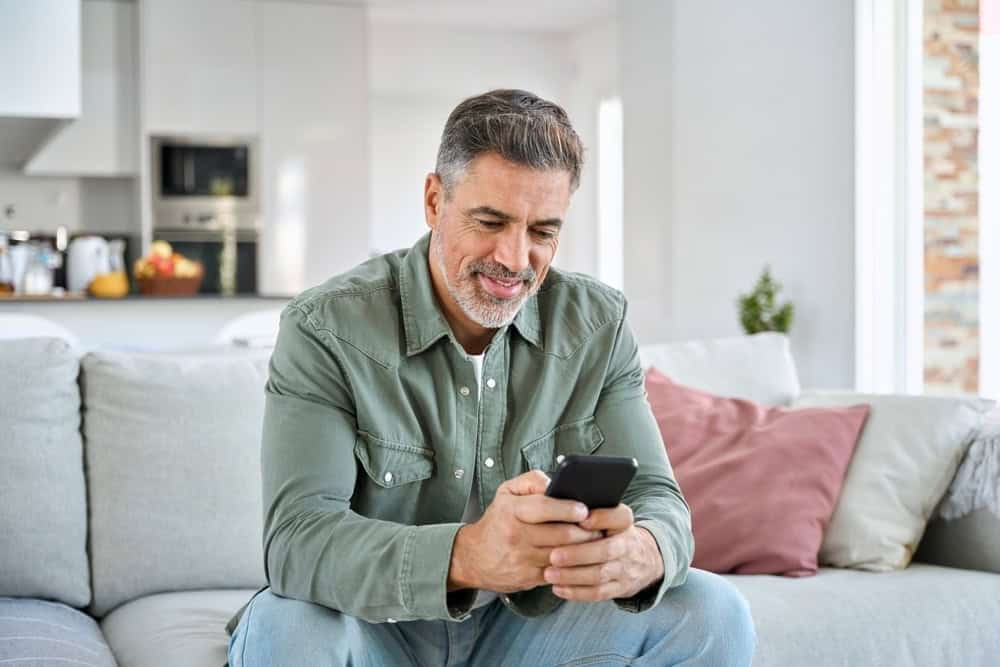 Man on a sofa considering online dating after going to rehab
