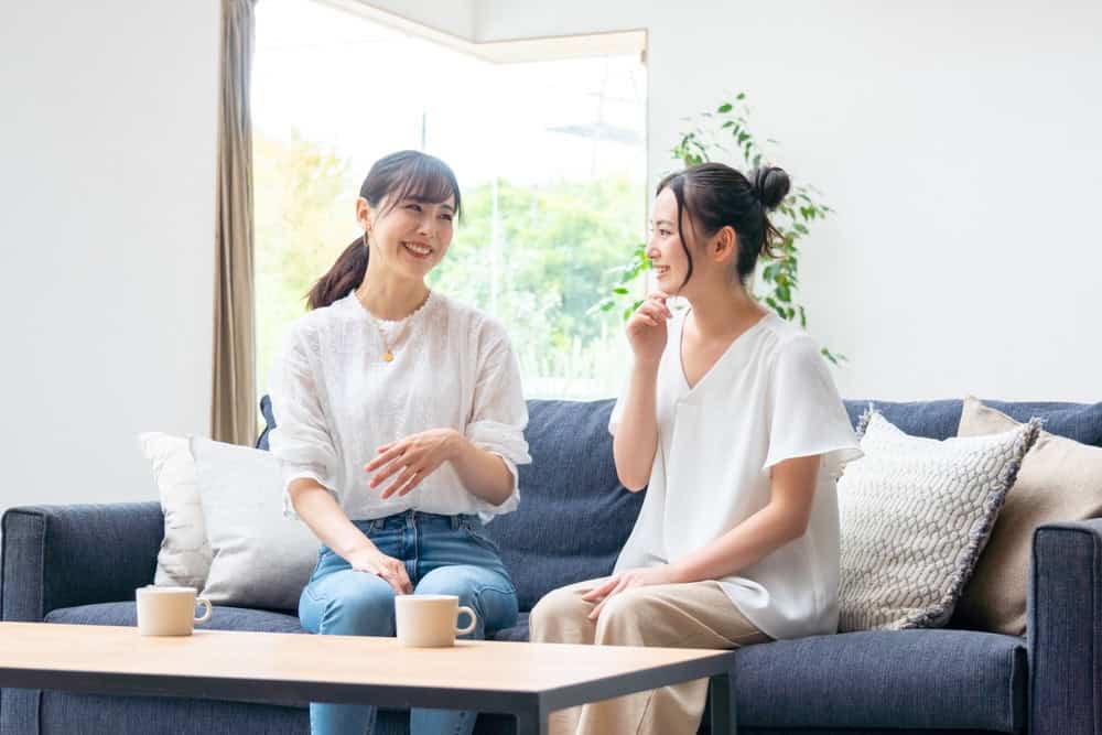 Two women in addiction recovery talking in a sober home