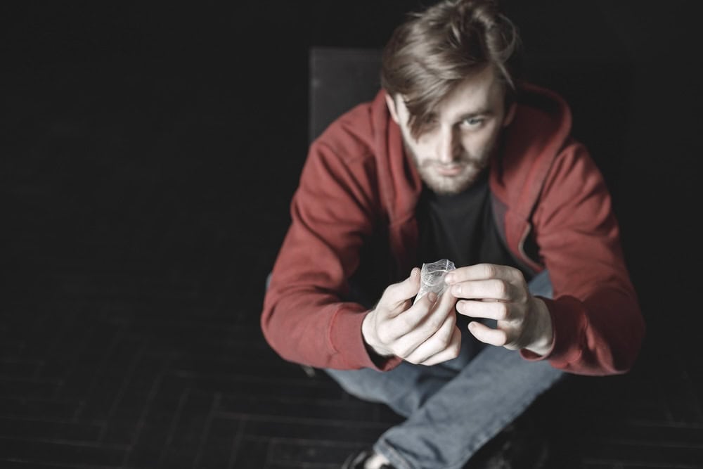 Man holding a small baggie of cocaine wondering if he can eat cocaine