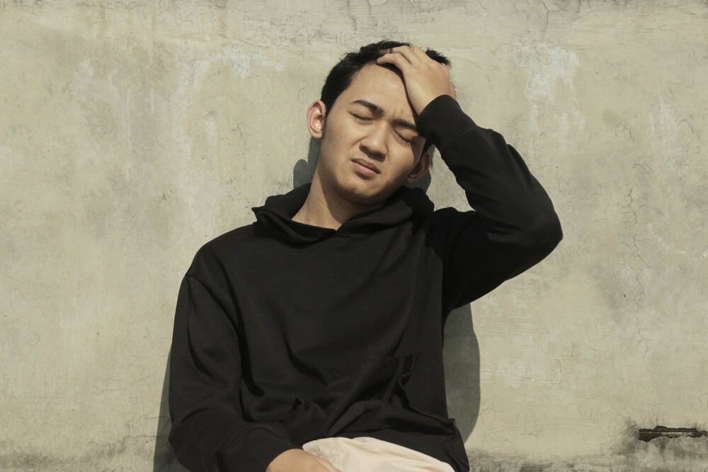 Young man on the floor greening out from too much weed use
