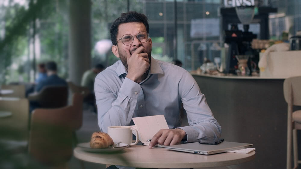 Adult male yawning while in a cafe 