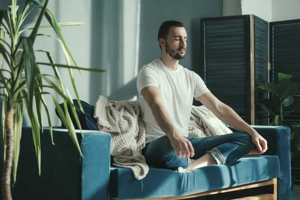 Man in addiction recovery from Anaheim drug rehab meditating for self-care 