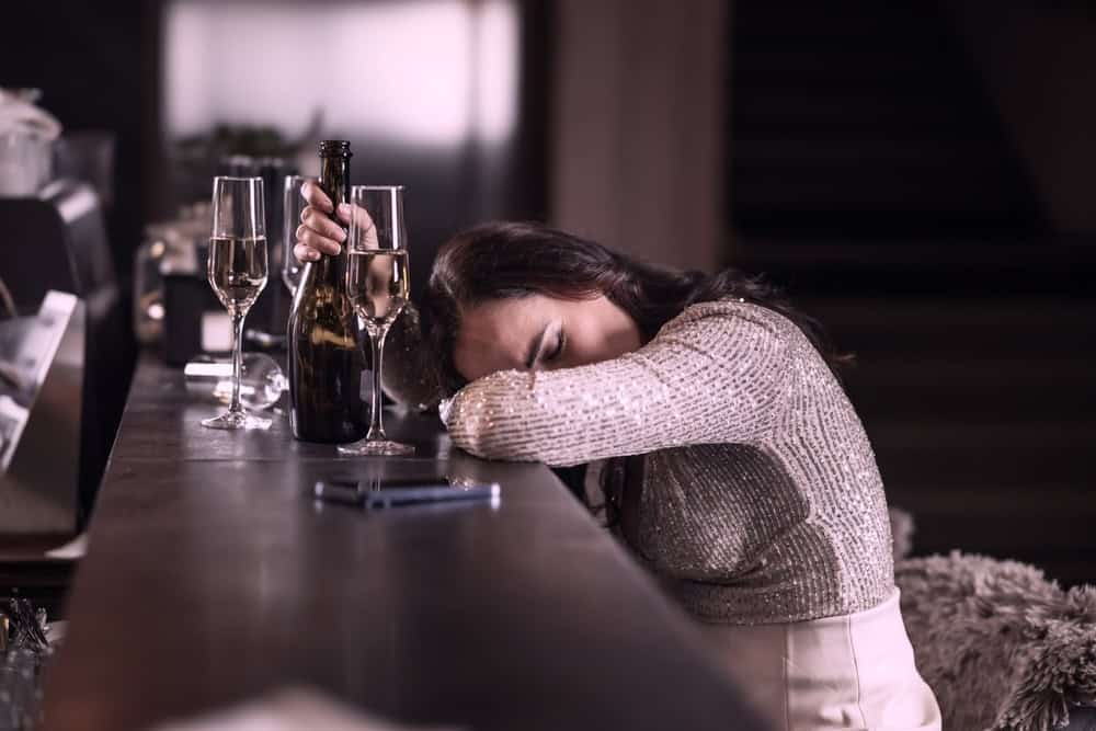 Drunk woman in a bar after drinking glasses of champagne
