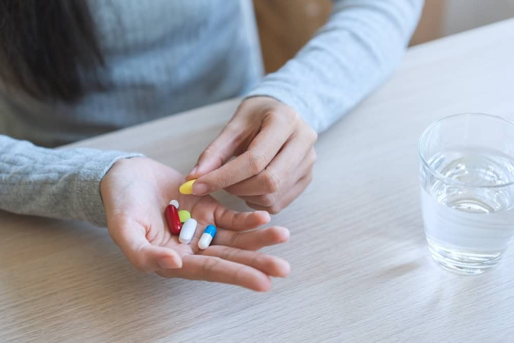 A man comparing different anxiety pills on his hand