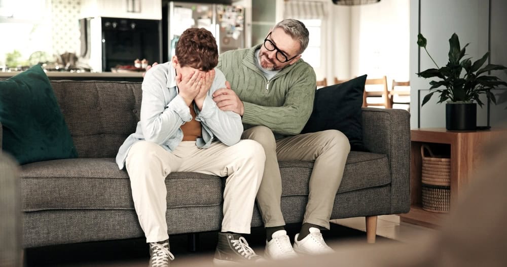 Father comforting his teenage son about failing a drug test